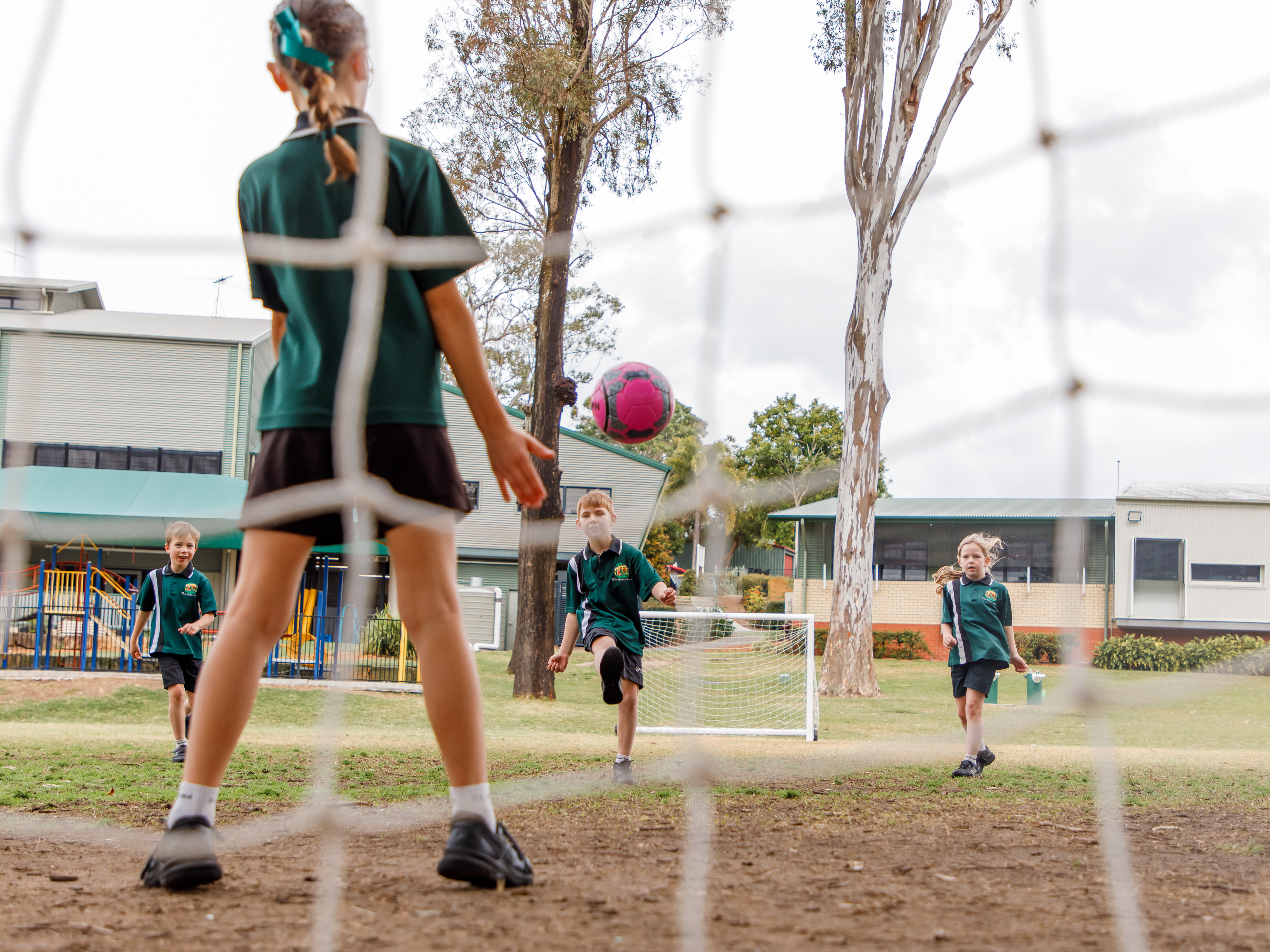 Students standing in a field playing soccer.